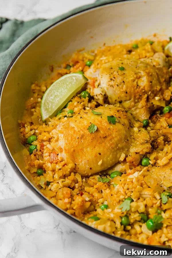 Close-up of golden-brown chicken thighs in a skillet, seared to perfection for cauliflower arroz con pollo.