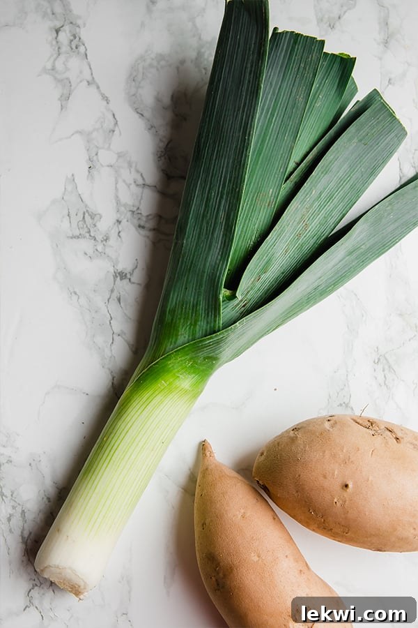 An assortment of fresh leeks and white sweet potatoes, ready for chopping and preparing this delicious soup.