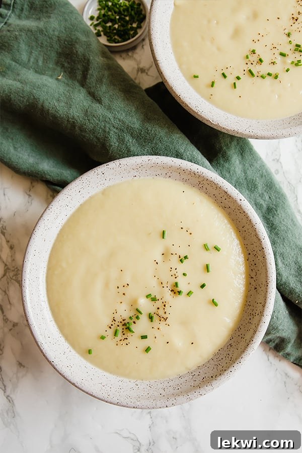 A close-up shot of a creamy sweet potato leek soup garnished with fresh herbs, ready to be enjoyed.