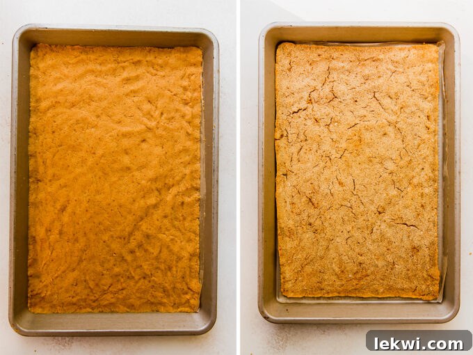 A baked pumpkin cake, golden brown and perfectly even, cooling on a parchment-lined jelly roll pan.