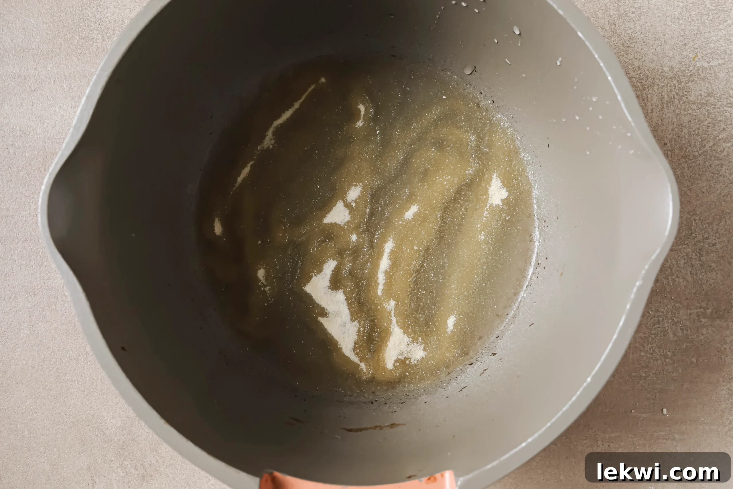 Gelatin egg mixture in a small pot, starting to harden after sprinkling gelatin over water.