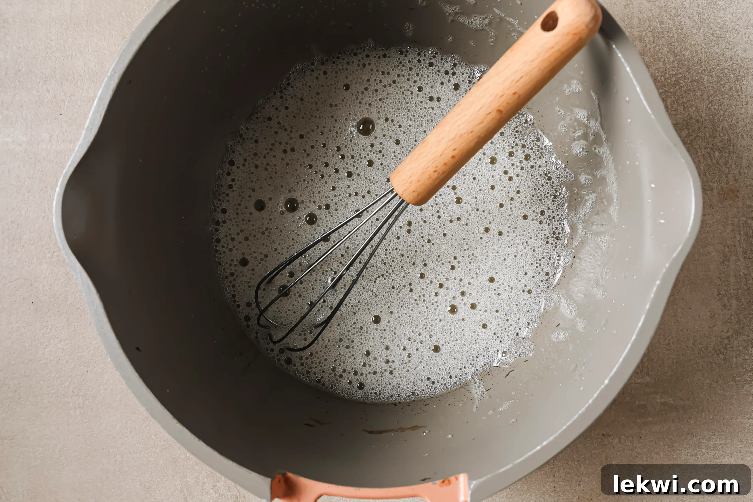 Frothed gelatin egg mixture in a pot after being gently heated and whisked.