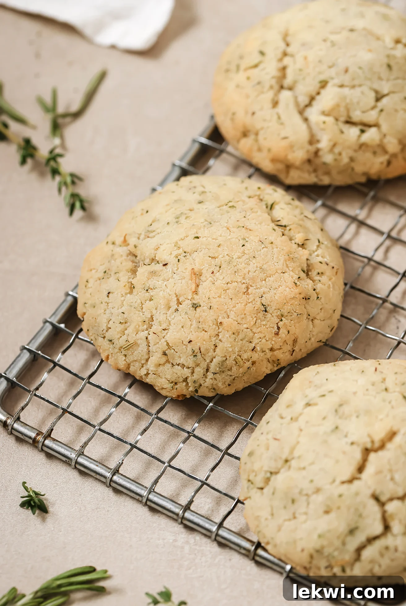 Garlic and herb dinner rolls on a wire rack with thyme in the background.