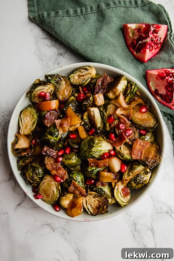A second close-up image of the roasted Brussels sprouts dish, highlighting the texture of the sprouts and the glistening pomegranate seeds.