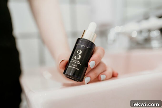 A hand holding a bottle of face serum.