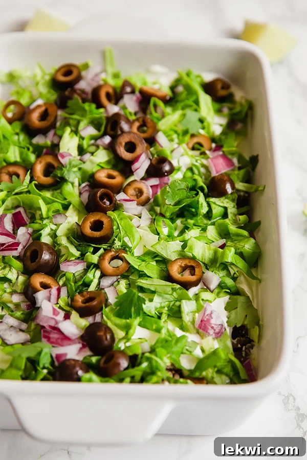A white baking dish filled with paleo taco dip, ready to be served.