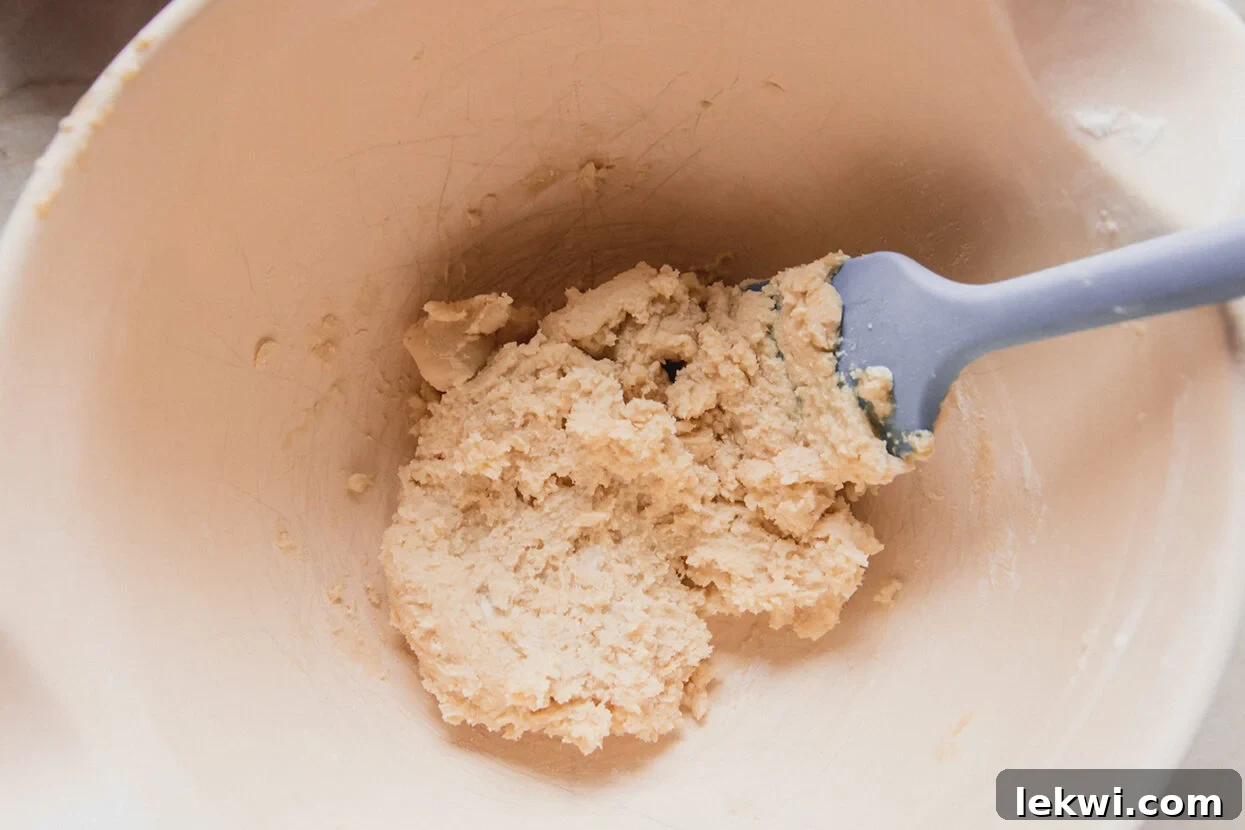 Spritz cookie dough in a bowl with a spatula. 