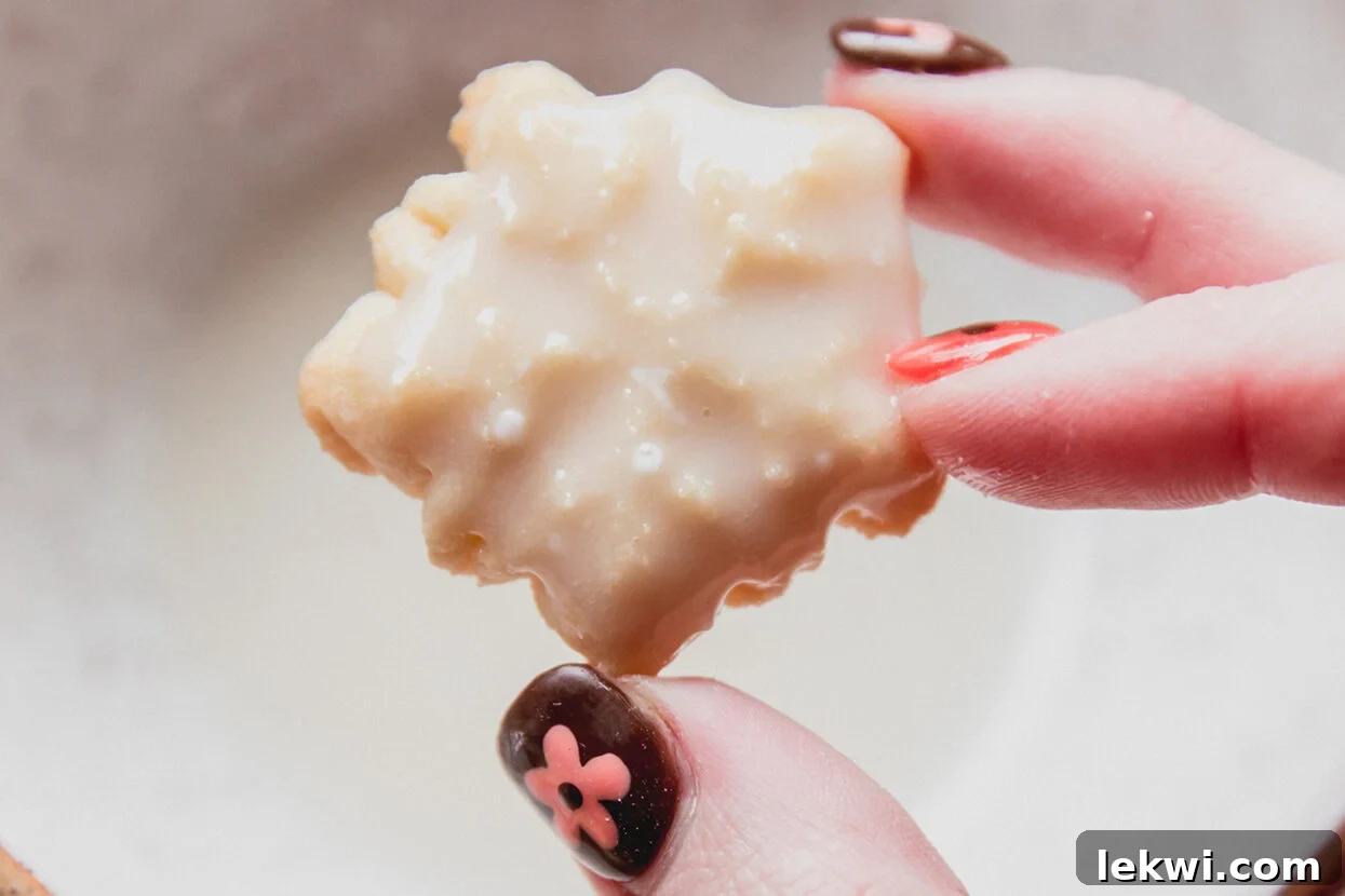 A snowflake shaped spritz cookie dipped in icing. 