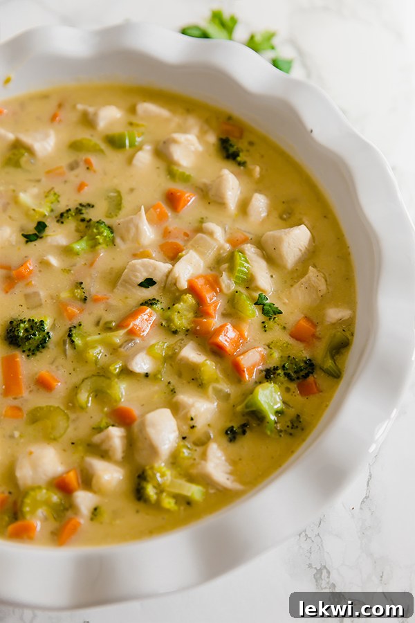 Close-up of the rich and creamy chicken pot pie filling with cubed chicken, carrots, broccoli, and celery, ready for the crust.