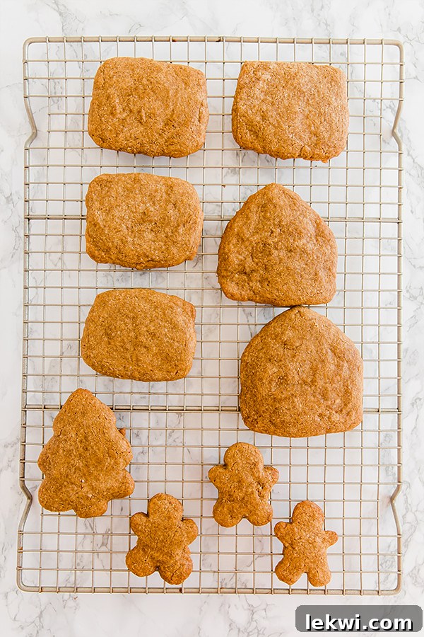 A wire rack with gingerbread cookies to make a gingerbread house cooling.