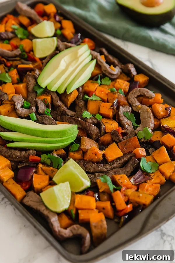 A vibrant sheet pan breakfast taco hash topped with fresh avocado slices, ready to be served.