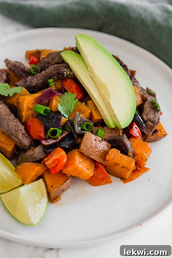 Breakfast Taco Hash served on a plate with avocado and lime slices.