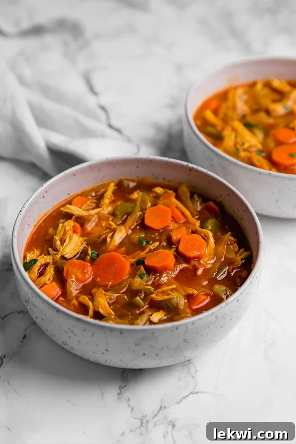 Two bowls of anti inflammatory turmeric cabbage soup sitting on the counter.