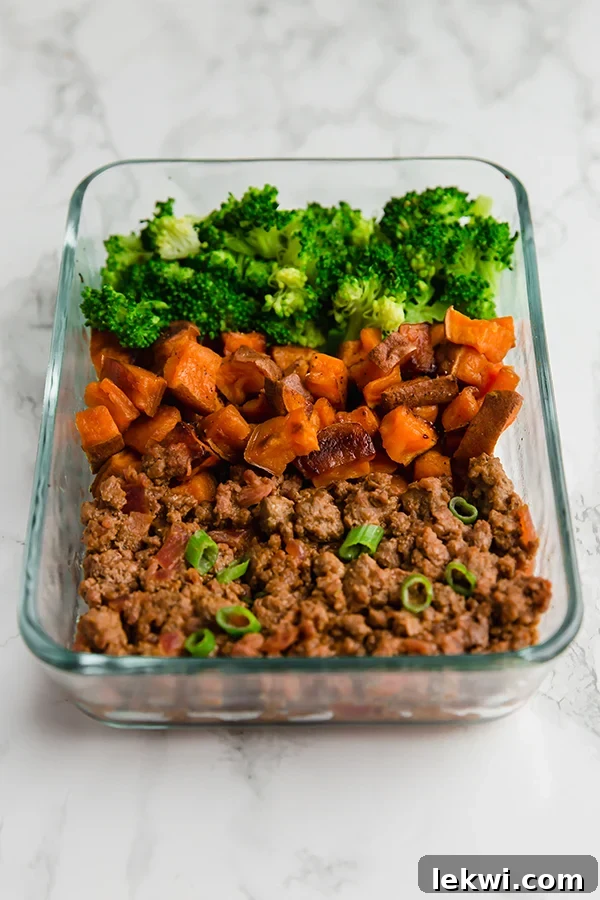Two glass meal prep containers filled with healthy sloppy joe, sweet potatoes, and broccoli