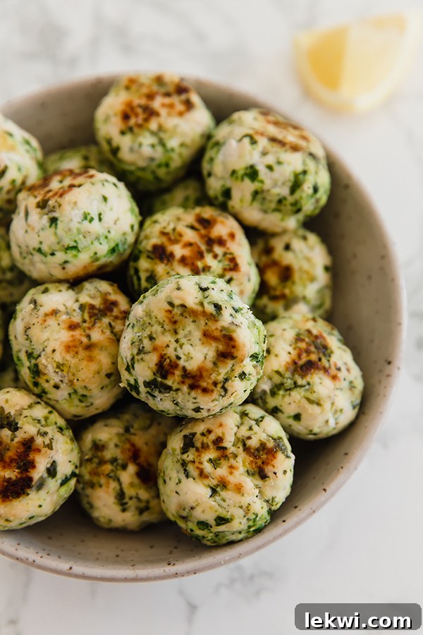 A close-up shot of Mediterranean veggie and chicken meatballs in a rustic bowl, highlighting their delicious texture and the fresh, healthy ingredients.