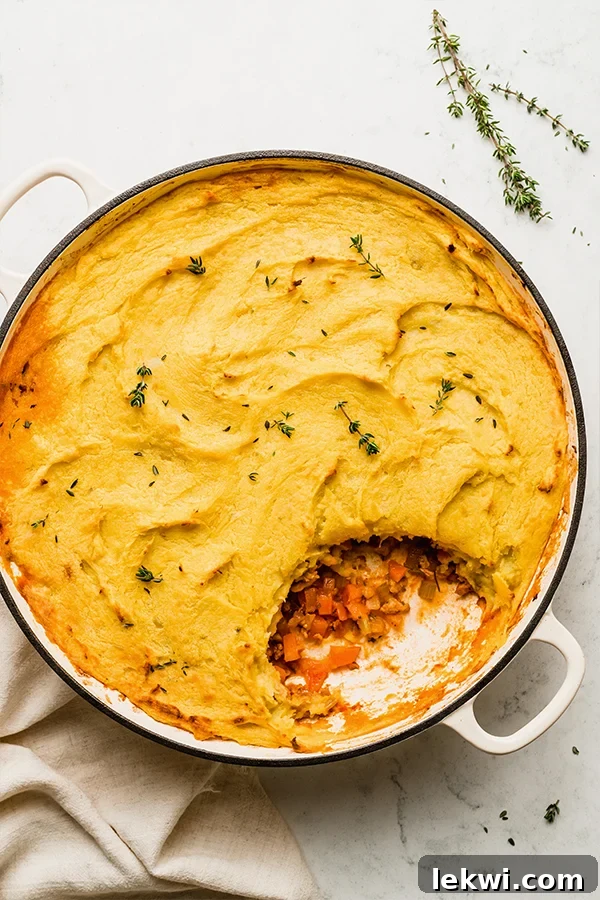 Pan of turkey shepherd's pie with a scoop missing, showcasing the creamy sweet potato topping and savory filling.
