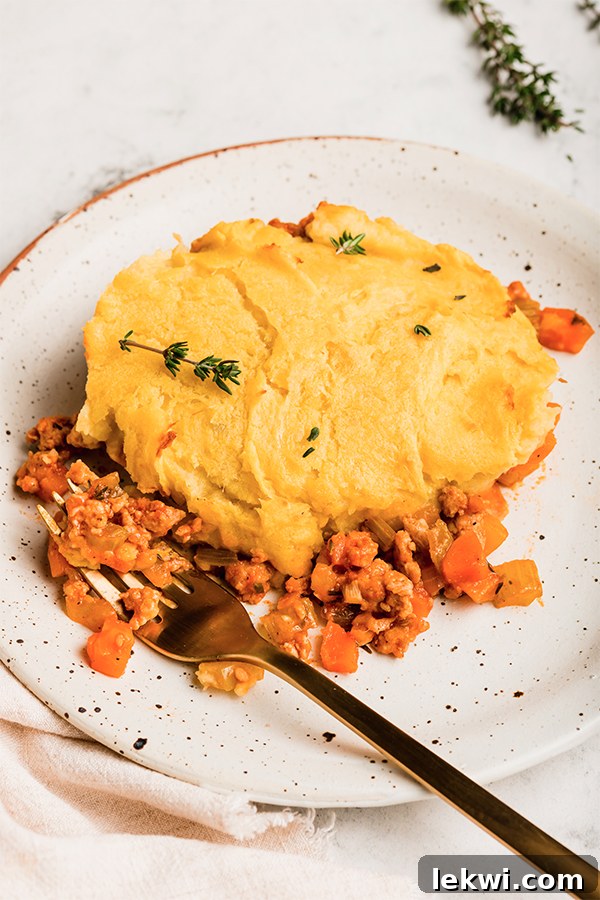 A serving of turkey shepherd's pie on a plate, showing the texture of the topping and filling.