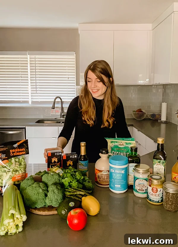 Michelle standing behind many grocery items on a counter before putting 