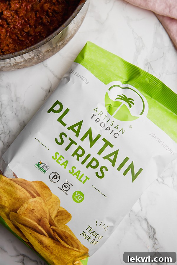 Plantain strips piled in a bowl next to a serving of chili.