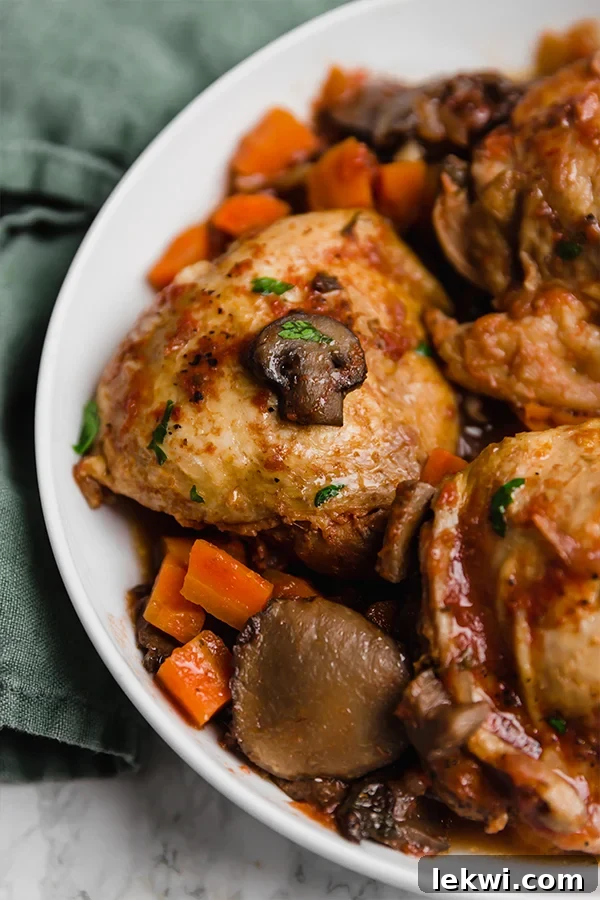 A white serving bowl with slow cooker chicken cacciatore after cooking and ready to be served.