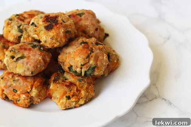 A white plate stacked with breakfast sausage poppers.
