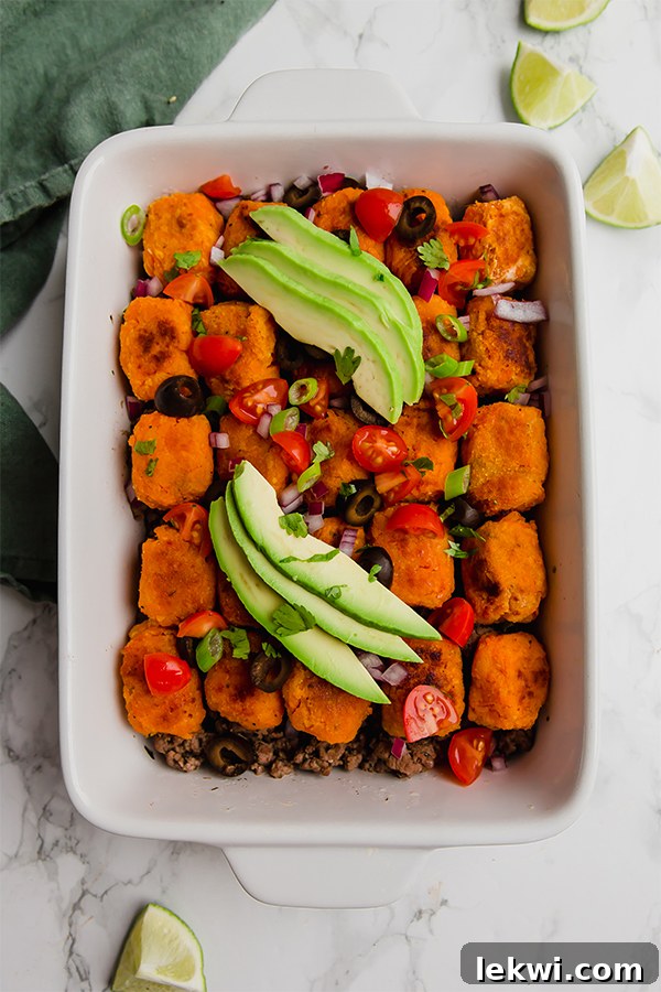 Sweet Potato Tater Tot Taco Casserole, garnished beautifully with fresh herbs and avocado.