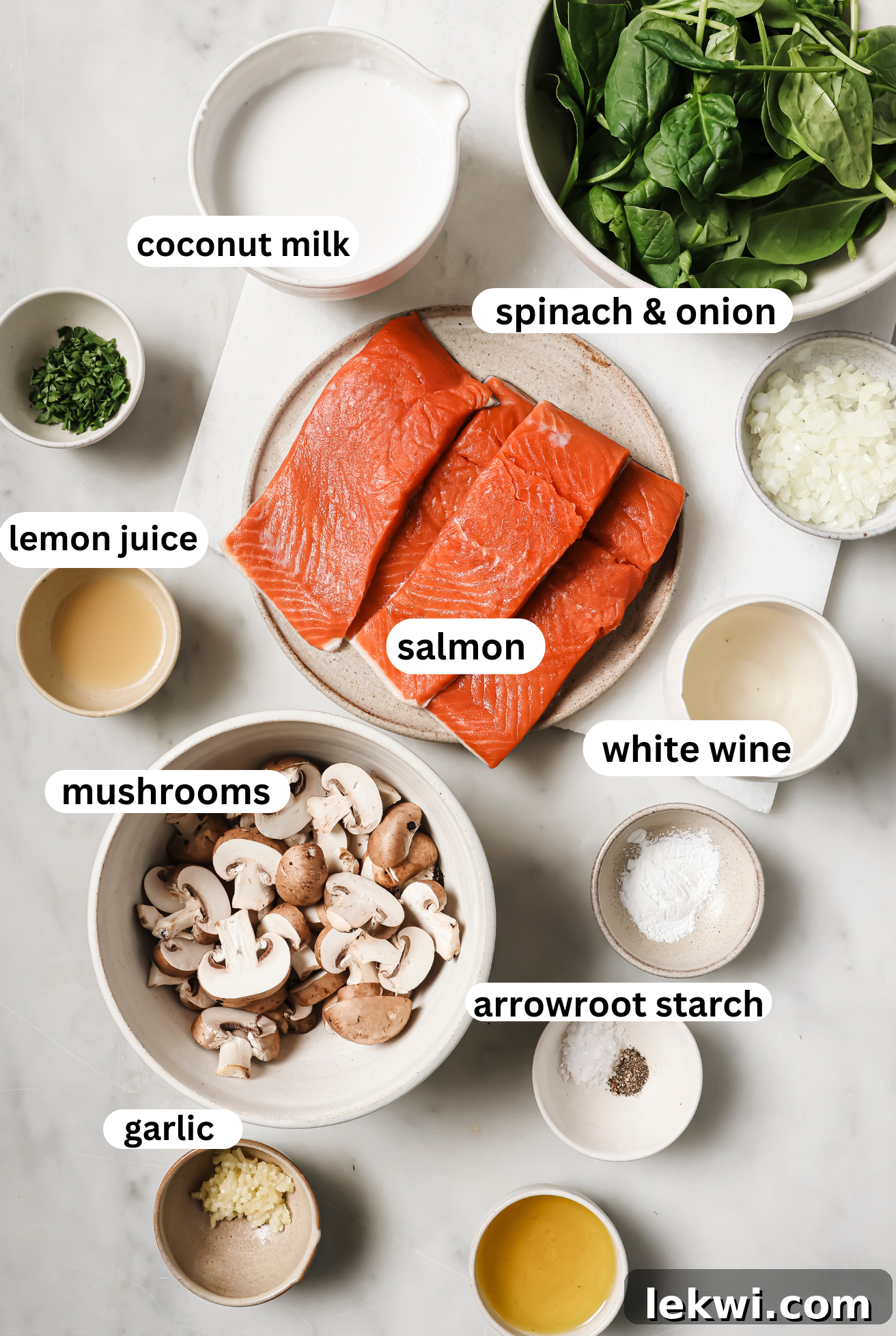 Salmon florentine ingredients laid out in bowls, including salmon fillets, coconut milk, spinach, mushrooms, and lemon.