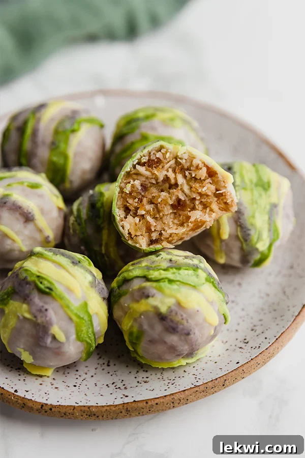 A white plate topped with king cake truffles with a bite taken out of one of them, drizzled with yellow, green, and purple frosting.