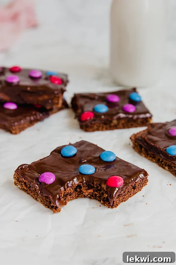 A bunch of cosmic brownies sitting out on a counter with a bite taken out of one of them. Delicious gluten-free and paleo brownies for a healthy treat.