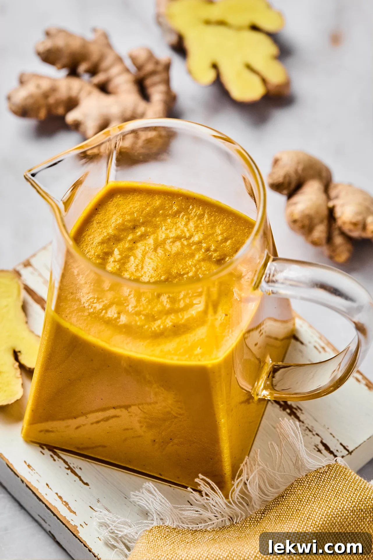 Japanese ginger dressing in a pitcher with fresh ginger on the side.
