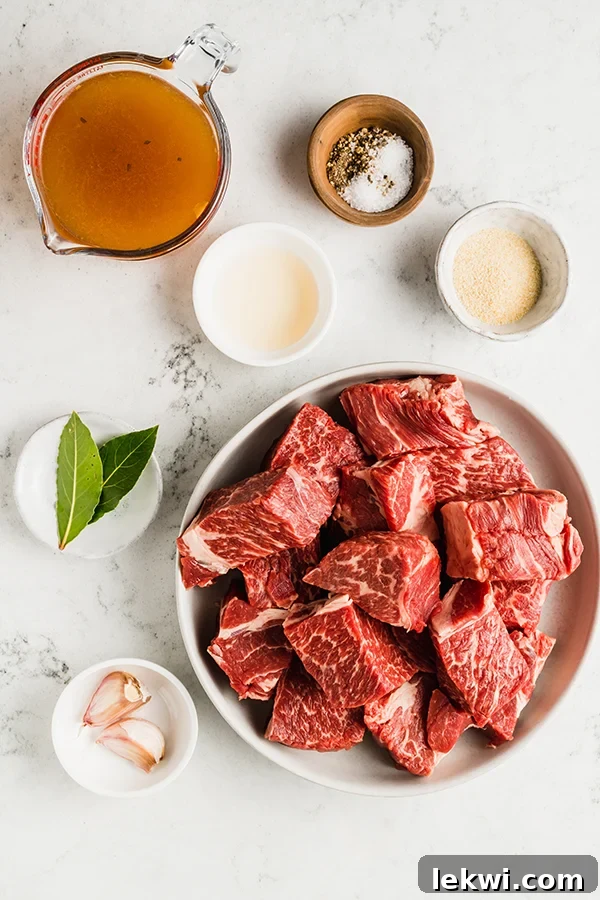 Separate bowls displaying all the ingredients for slow cooker shredded beef: chuck roast, beef broth, salt, pepper, bay leaves, garlic, and onion powder.