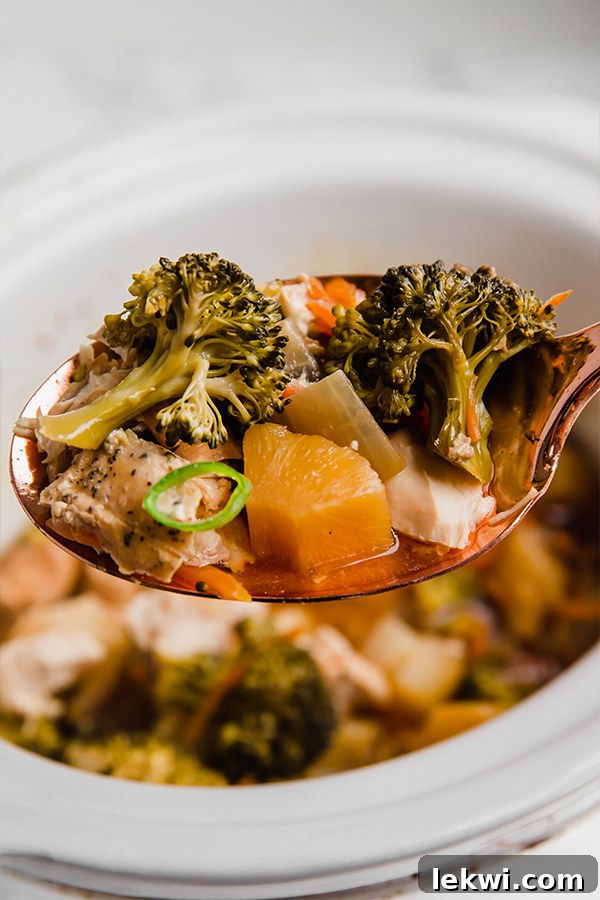 Slow-cooked Hawaiian chicken simmering gently in the slow cooker, filled with juicy chicken, bright pineapple, and tender vegetables, ready to be served.