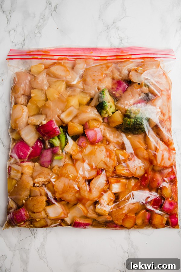 A freezer bag filled with all the uncooked ingredients for Hawaiian chicken, ready for future slow cooking, showcasing the convenience of meal prepping.