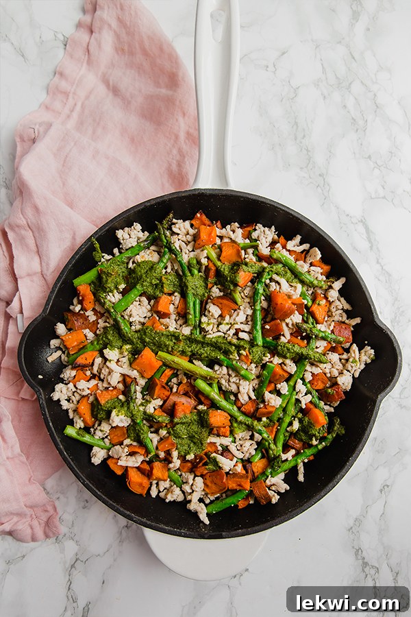 Harvest Turkey Skillet with Sweet Potatoes and Asparagus 3 A delicious serving of asparagus, turkey, and sweet potato skillet on a white plate, showcasing the rich colors and inviting textures of the dish.