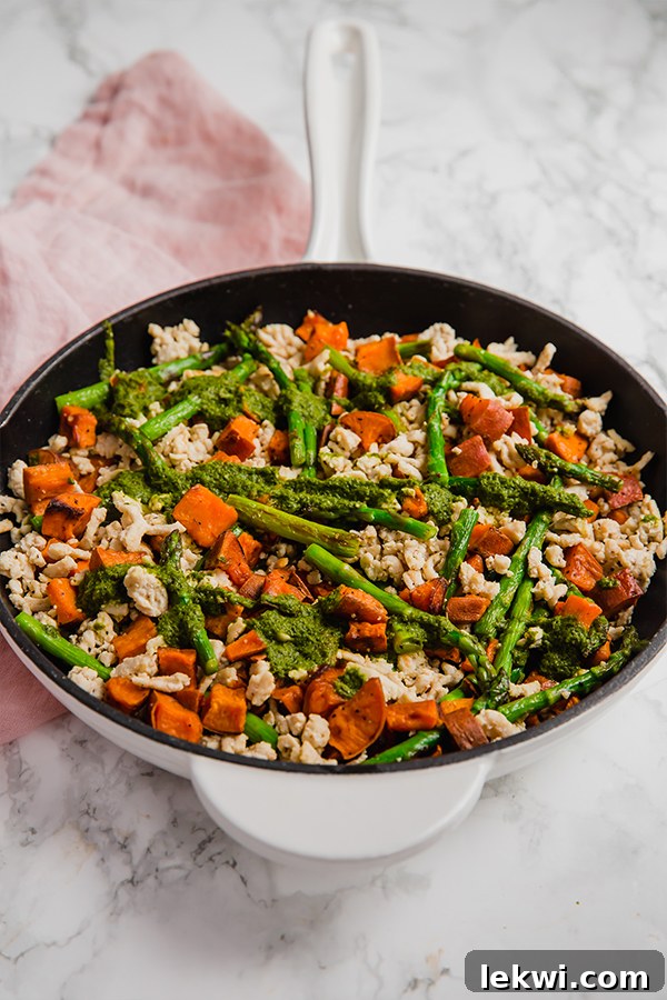 Harvest Turkey Skillet with Sweet Potatoes and Asparagus 4 Overhead shot of the cooked asparagus, turkey, and sweet potato skillet in a rustic pan, showcasing the golden-brown sweet potatoes and vibrant green asparagus.