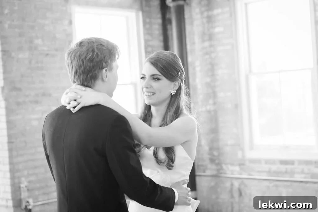 A black and white photo of a bride dancing with the groom.