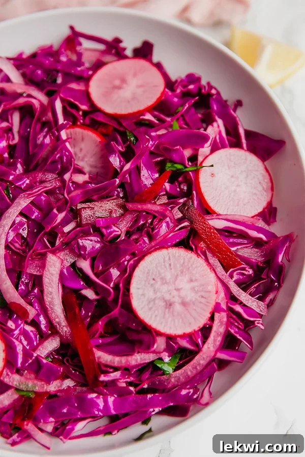 Vibrant Purple Coleslaw in a white bowl, garnished with fresh parsley.
