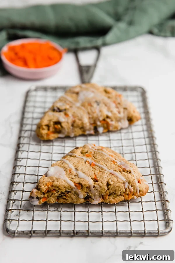 A wire rack with two carrot cake scones cooling on it.