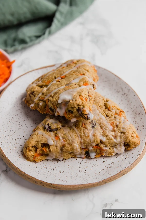 Carrot Cake Scones with a drizzle of white frosting on a plate.