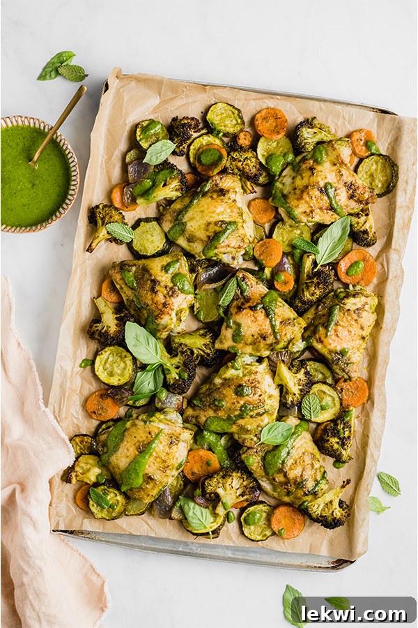 Chicken pesto with vegetables on a lined baking dish, ready to be served.