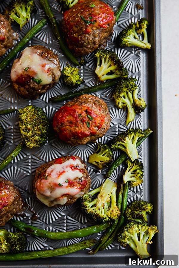 Italian-style mini meatloaf arranged on a sheet pan with roasted vegetables.