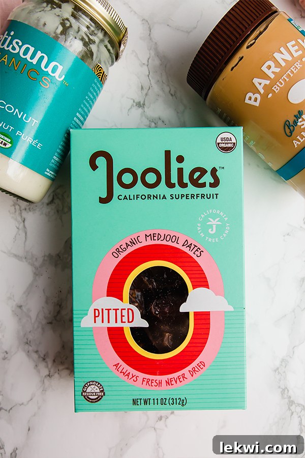 A box of organic dates, coconut butter, and almond butter on a counter.