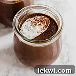 A glass jar filled with homemade chocolate pudding, garnished.