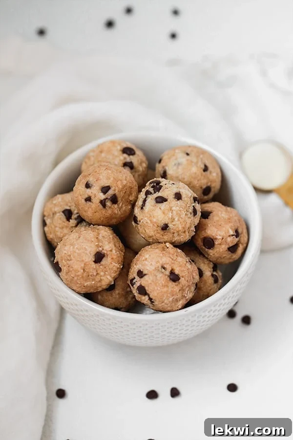 A white bowl filled with cookie dough protein bites in it.