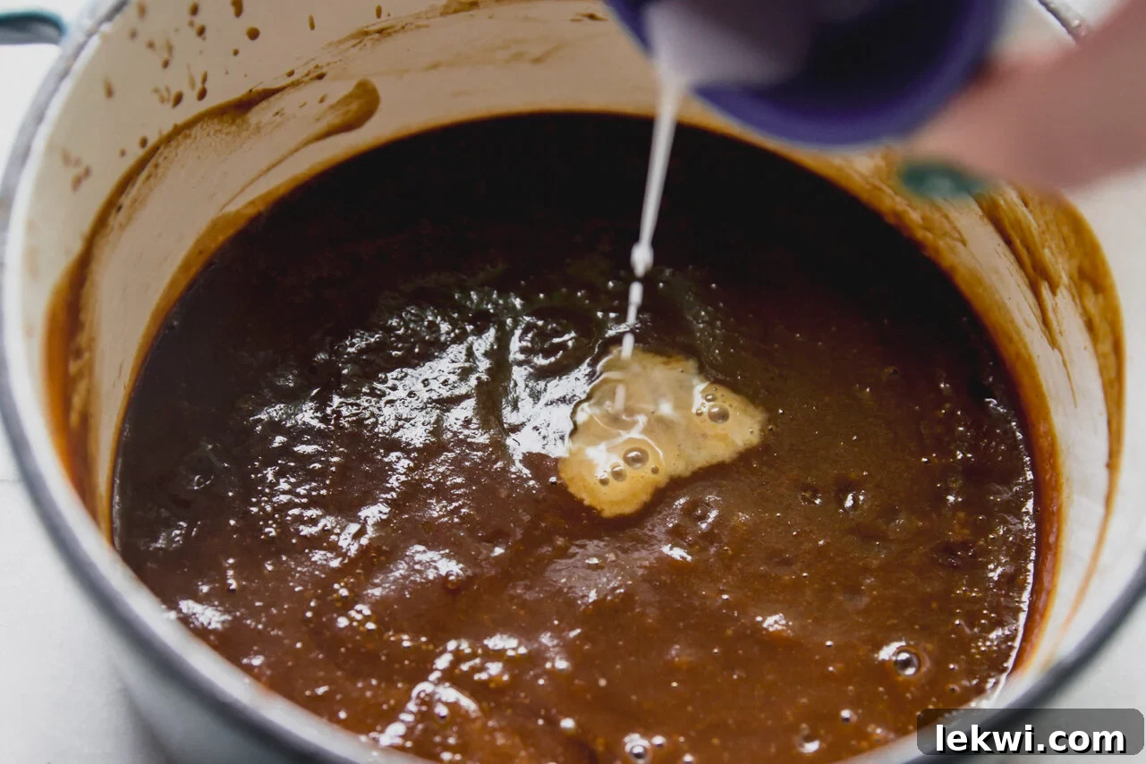 BBQ sauce with arrowroot slurry being poured in.