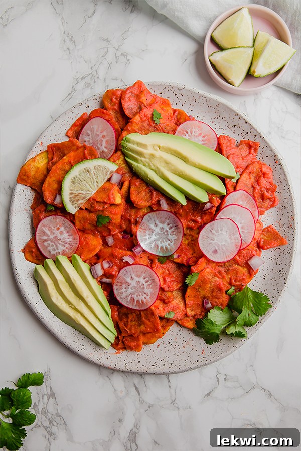 A vibrant plate of plantain chilaquiles adorned with thinly sliced radishes and creamy avocado, capturing the dish's fresh and appetizing appeal.