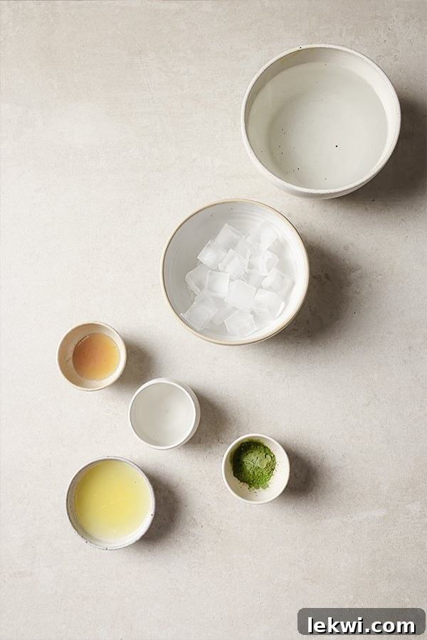 Assortment of fresh ingredients for matcha lemonade: honey, lemon juice, and matcha green tea powder.