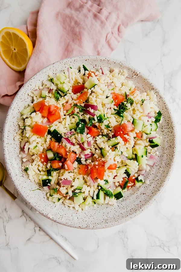 Cauliflower Tabbouleh Salad in a glass bowl, garnished with fresh mint.