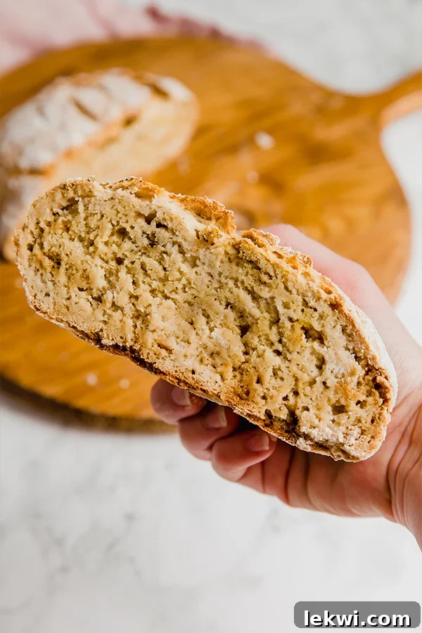 A half loaf of no knead gluten free bread being held in a hand.