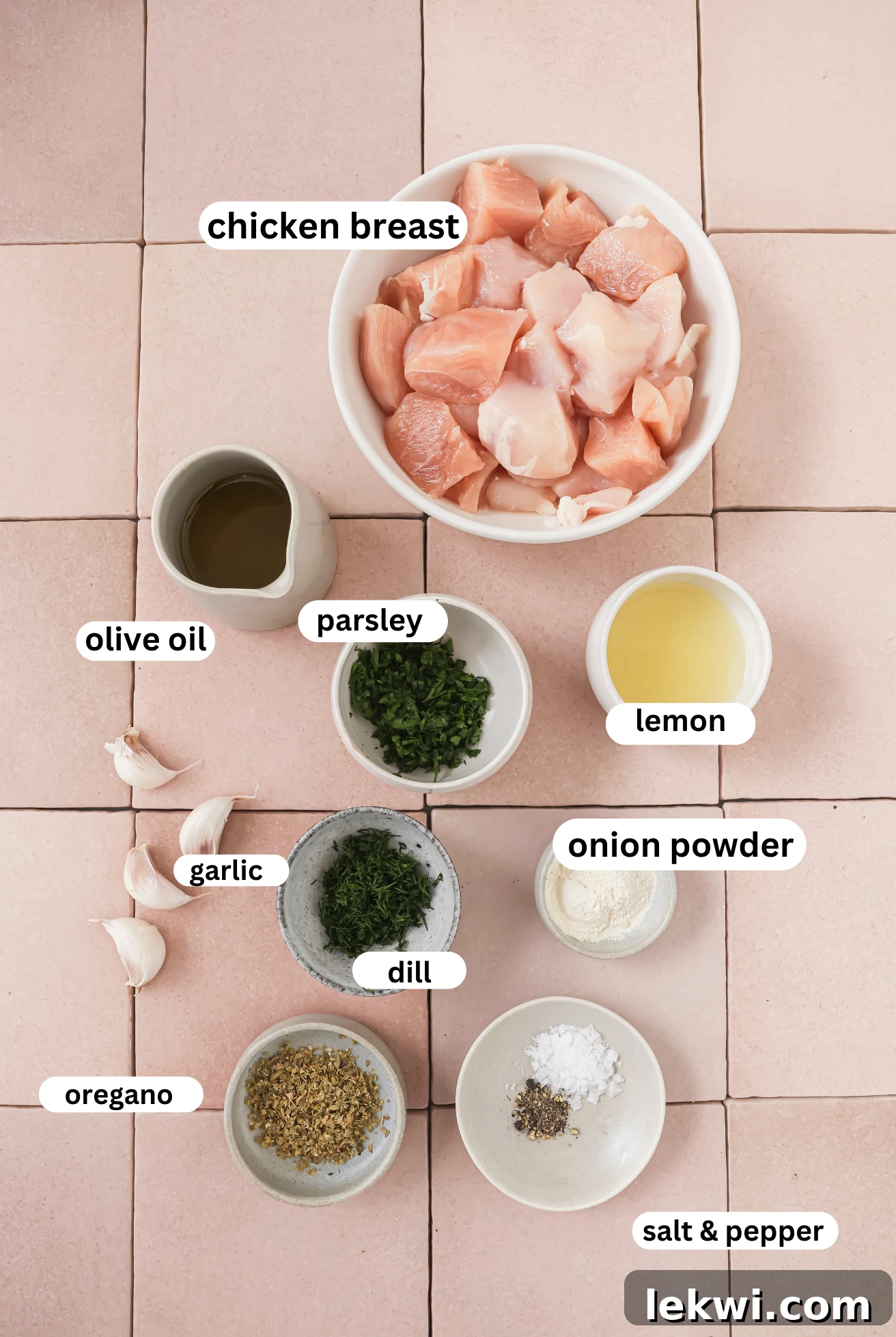 Chicken souvlaki ingredients in separate bowls, including lemon, garlic, herbs, and spices.